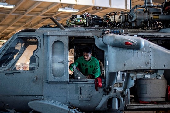 Aviation Structural Mechanic 2nd Class Afenu Godwin cleans the forward bell crank of an MH-60S Sea Hawk aboard USS Harry S. Truman.